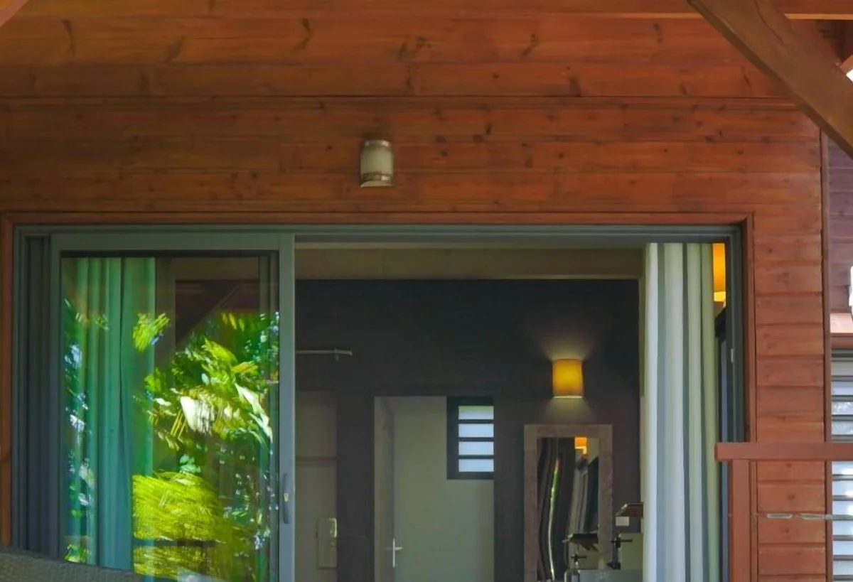 La terrasse en bois d'un lodge devant sa baie vitrée