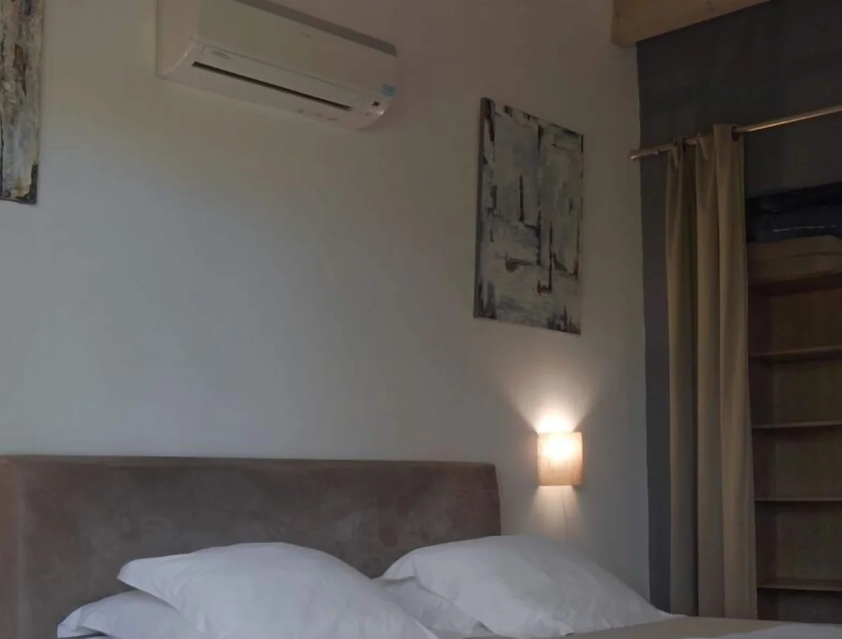 Le lit queen size d'un lodge, la climatisation au-dessus