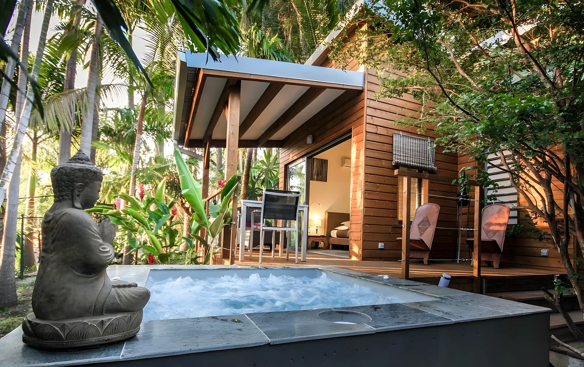 Le jacuzzi et le bouddha de pierre devant un lodge