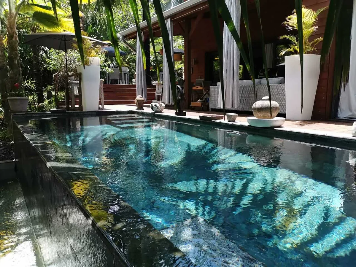 La piscine du lodge, bordée de palmiers et de plantes tropicales