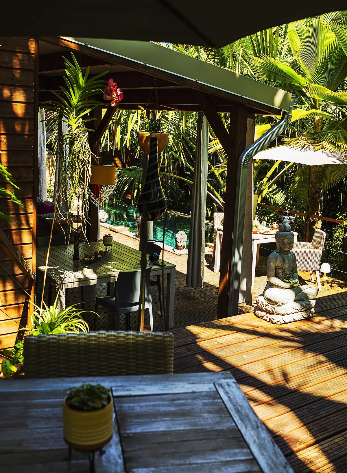 La varangue en bois d'un lodge, ouverte sur le jardin